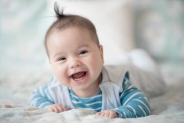 Smiling baby boy in striped blue shirt, representing modern English baby boy names